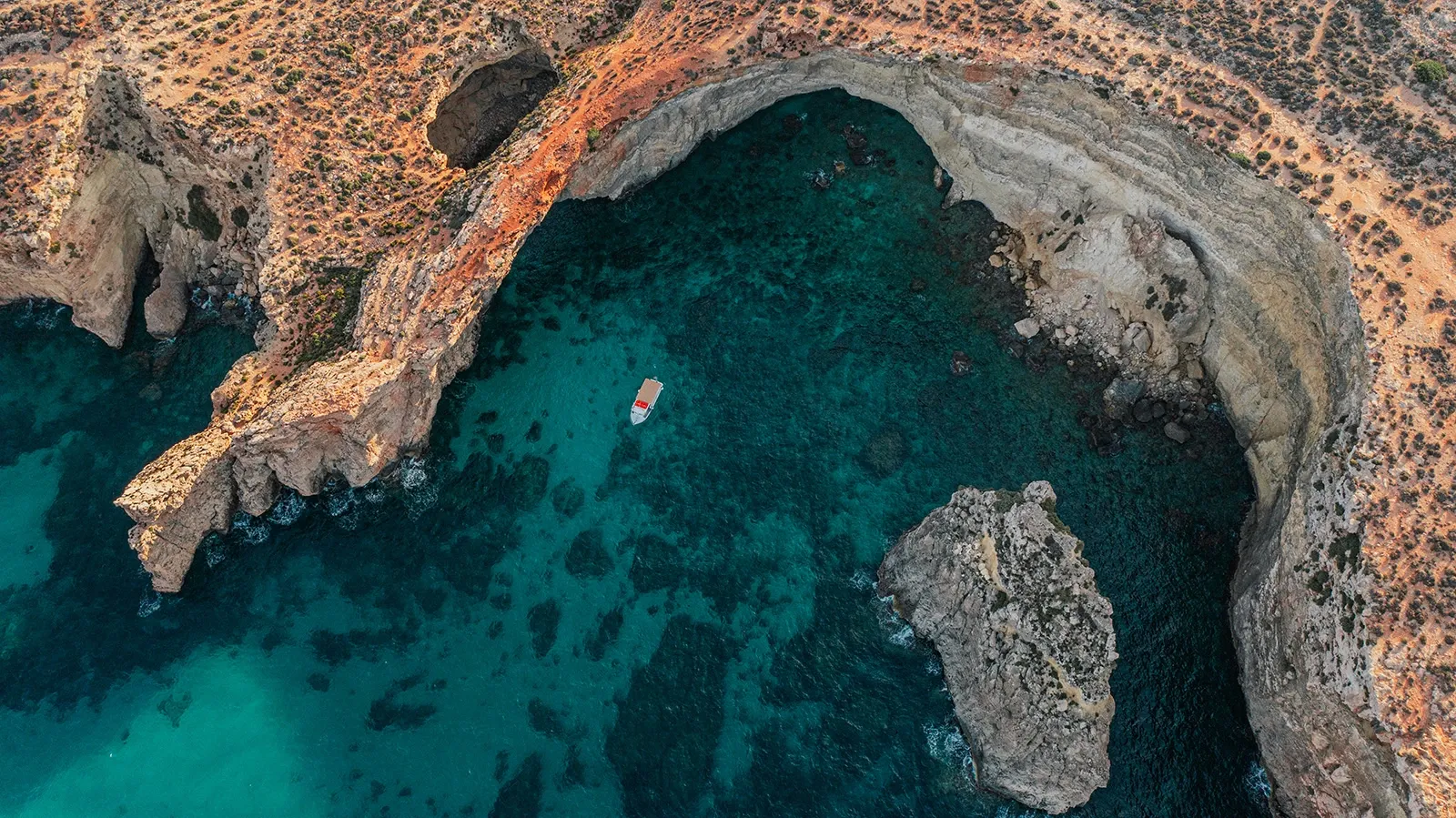 Rocky coastal inlet and natural formations around Comino