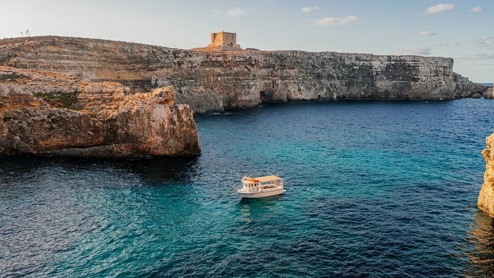 Boat and rocky coastline around Comino